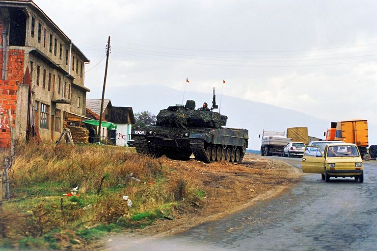 Ein Kampfpanzer Leopard 2 der Bundeswehr steht im August 1999 an einer Straße. Die Friedenstruppe KFOR zeigt in diesen ersten Wochen nach dem Krieg deutlich Präsenz. Foto: DBwV/Yann Bombeke