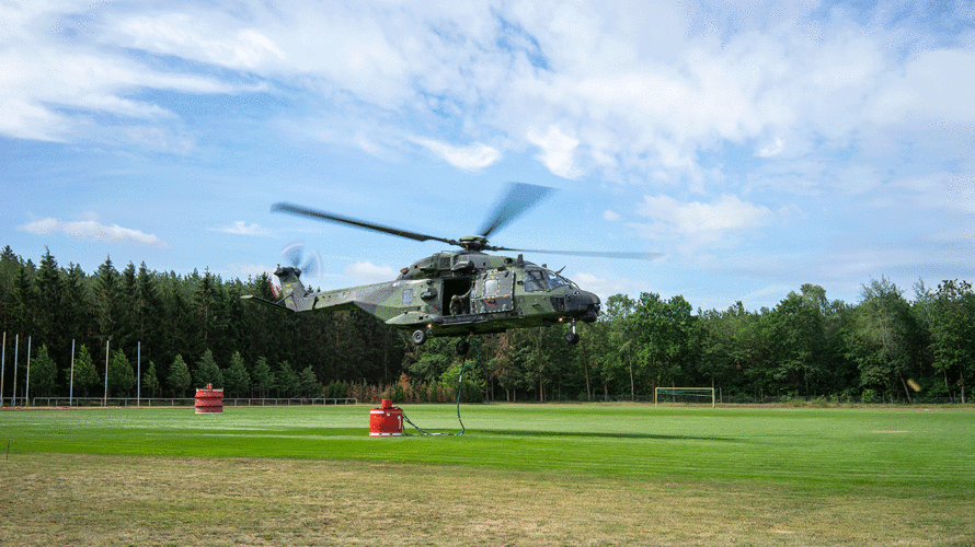 Ein Transporthubschrauber NH90 landet auf dem Sportplatz von Lübtheen mit einem Löschwassertank. Es ist das erste Mal, dass der NH90 mit Wasser als Außenlast eingesetzt wird. Foto: DBwV/Bombeke