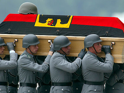 Bundeswehrsoldaten tragen am 10. Juni 2003 auf dem militärischen Teil des Köln-Bonner Flughafens den Sarg eines gefallenen Kameraden. Vier deutsche ISAF-Soldaten waren drei Tage zuvor in Kabul einem Selbstmordanschlag zum Opfer gefallen. Foto: picture alliance/Associated Press/Michael Sohn