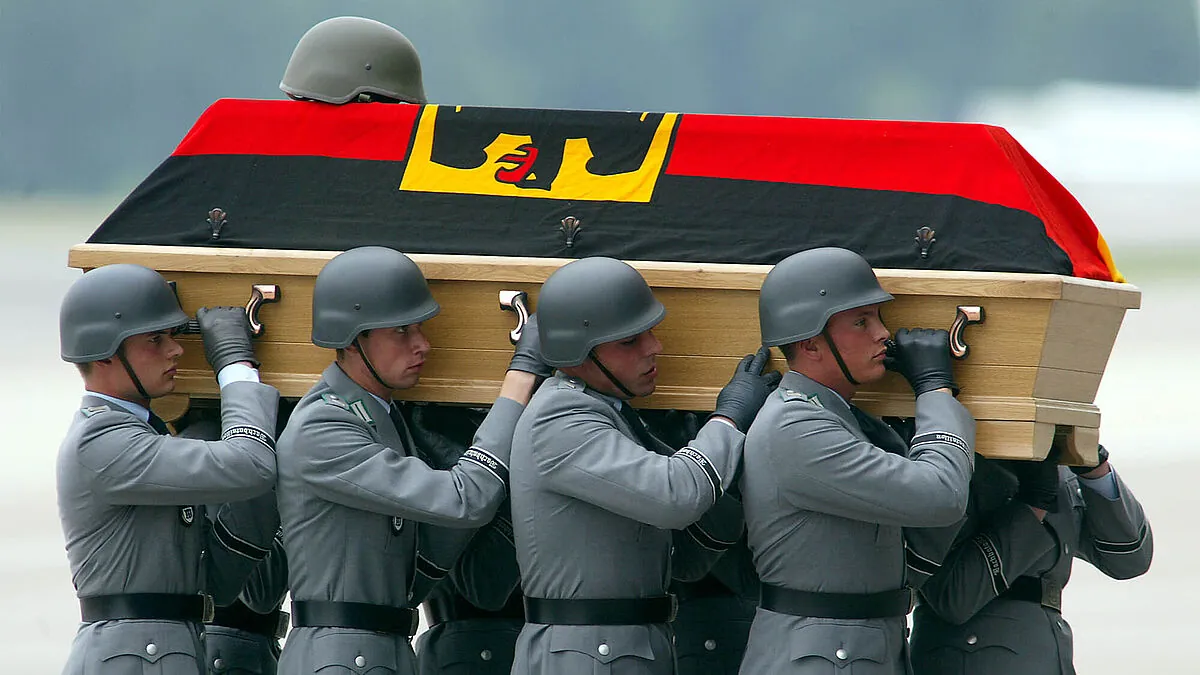 Bundeswehrsoldaten tragen am 10. Juni 2003 auf dem militärischen Teil des Köln-Bonner Flughafens den Sarg eines gefallenen Kameraden. Vier deutsche ISAF-Soldaten waren drei Tage zuvor in Kabul einem Selbstmordanschlag zum Opfer gefallen. Foto: picture alliance/Associated Press/Michael Sohn