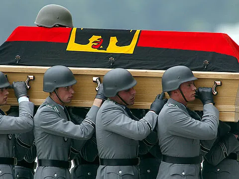 Bundeswehrsoldaten tragen am 10. Juni 2003 auf dem militärischen Teil des Köln-Bonner Flughafens den Sarg eines gefallenen Kameraden. Vier deutsche ISAF-Soldaten waren drei Tage zuvor in Kabul einem Selbstmordanschlag zum Opfer gefallen. Foto: picture alliance/Associated Press/Michael Sohn
