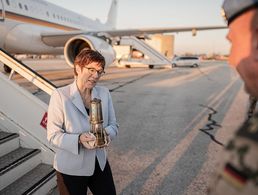 Verteidigungsministerin Annegret Kramp-Karrenbauer geht mit einer Laterne mit dem Friedenslicht, welches aus Bethlehem über die Verbände der Pfadfinder an die Militärseelsorge übergeben wird, von der Flugzeugtreppe zu Peter Bellinghausen, Militärpfarrer. Foto: picture alliance/Michael Kappeler/dpa