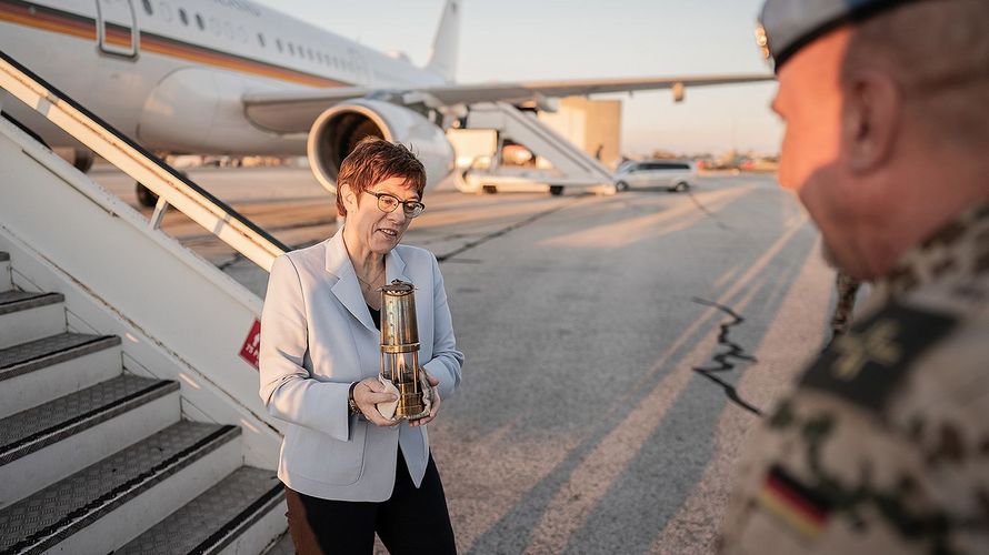 Verteidigungsministerin Annegret Kramp-Karrenbauer geht mit einer Laterne mit dem Friedenslicht, welches aus Bethlehem über die Verbände der Pfadfinder an die Militärseelsorge übergeben wird, von der Flugzeugtreppe zu Peter Bellinghausen, Militärpfarrer. Foto: picture alliance/Michael Kappeler/dpa