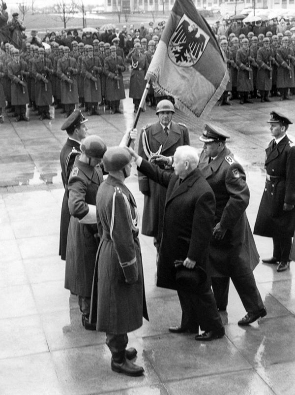 Bundespräsident Heinrich Lübke überreicht am 7. Januar 1965 dem Wachbataillon der Bundeswehr in Bonn stellvertretend für die gesamten Streitkräfte der Bundeswehr die allererste neue Truppenfahne. Foto: picture-alliance/dpa