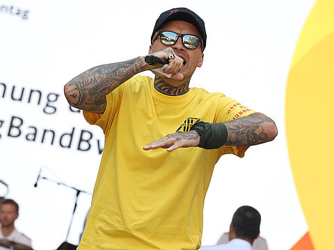 Veteranen haben etwas zu sagen: Der Rapper und Afghanistan-Veteran Mazibora eröffnete den Veteranentag in Berlin gemeinsam mit der Big Band der Bundeswehr. Foto: DBwV/Yann Bombeke