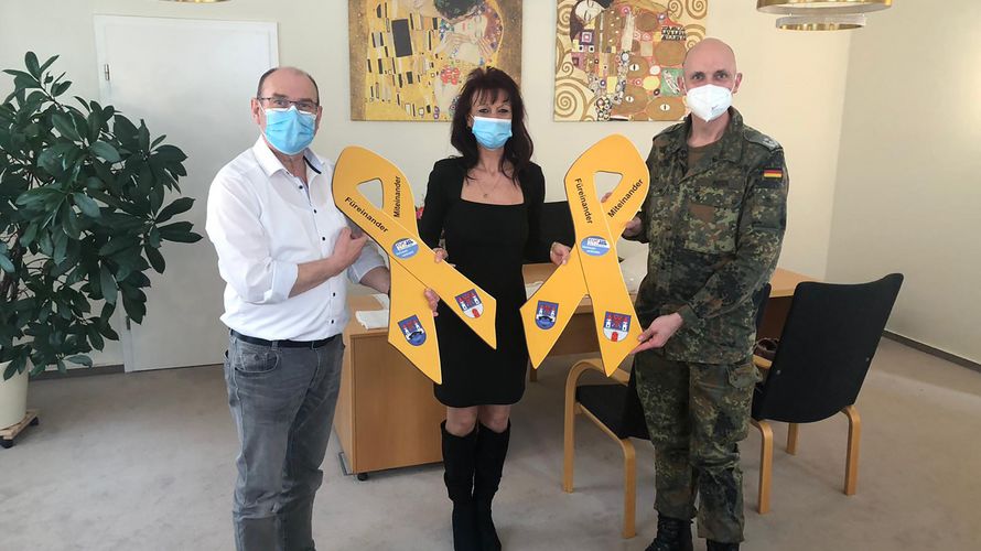 Havelbergs Bürgermeister Bernd Poloski (l.) und Oberstleutnant Ralph Peter (r.) nehmen im Rathaus die „Gelben Schleifen“ von Katrin van Treek entgegen. Foto: Hauptfeldwebel Markus Necker