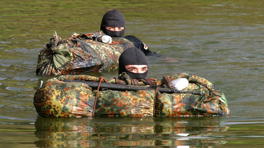 Soldaten eines Einsatzkommandos durchqueren mit ihrer persönlichen Ausrüstung bei der Eignungsfeststellung zur Aufnahme in das Kommando Spezialkräfte eine Wasserstelle. Die Soldaten zeigen damit körperliche Leistungsfähigkeit und Teamgeist Foto: Bundesweh