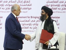 Handschlag in Doha: Der Sonderbeauftragte der US-Regierung Zalmay Khalilzad (l.) und der Taliban-Mitbegründer Mullah Abdul Ghani Baradar besiegeln in Katar das Friedensabkommen. Foto: picture alliance / AA