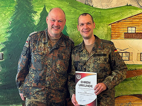 Bezirksvorsitzender Oberstabsfeldwebel Dieter Götz (l.) dankt StoKa-Vorsitzenden Major Thomas Zimmermann mit der Verdienstnadel in Bronze. Foto: Berger