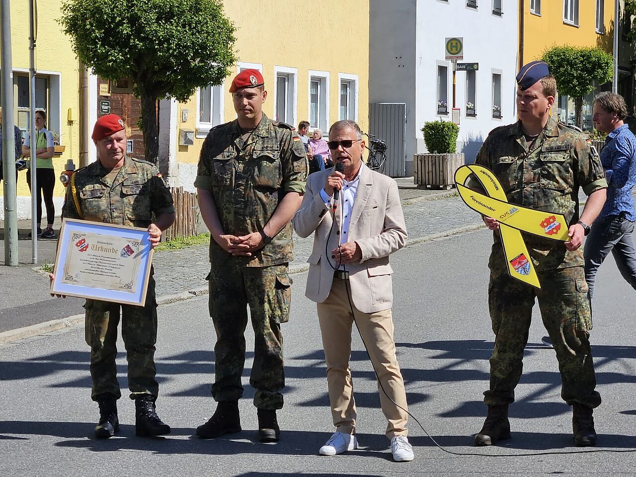 Die feierliche Übergabe der „Gelben Schleifen“ durch Bezirksvorsitzenden Stabsfeldwebel Christian Schleicher an den Ersten Bürgermeister Karlheinz Budnik unterstützte eine Abordnung der Pateneinheit des PzArtBtl 131 unter Führung von Batteriechef Major Knorn. Foto: DBwV/Christian Schleicher