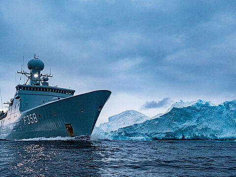 Die Fregatte „HDMS Triton” der Königlich Dänischen Marine passiert einen Eisberg in den Gewässern um Grönland: Auch auf die Seefahrt wirkt sich der Klimawandel in vielen Bereichen aus. Foto: NATO/Flickr