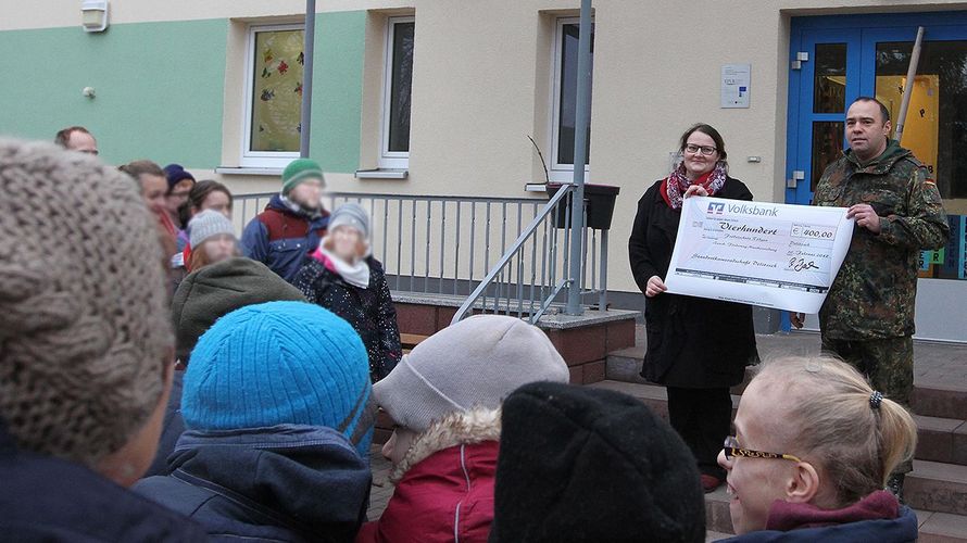 Hauptmann Ralf Baasch bei der Scheckübergabe an die Schulleiterin Anna Maria Kenzig.