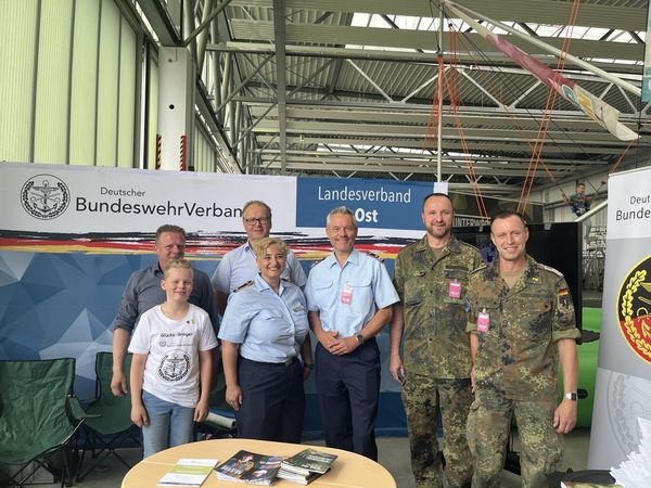 Am Stand des DBwV in Holzdorf (v.l.n.r.): Björn Hellmund (mit Sohn, Mitarbeiter Außendienst LV Ost), Stabsfeldwebel a.D. Peter Goldammer (Standortbeauftragter Schönewalde/Holzdorf), Hülya Süzen (Stellvertretende Vorsitzende Luftwaffe), Oberstleutnant Dr. Detlef Buch (Vorsitzender Fachbereich Besoldung, Haushalt und Laufnahnrecht), Stabsfeldwebel Tino Nicolai (Bezirksvorsitzender Sachsen-Anhalt) und Hauptfeldwebel Tommy Schmidt. Foto: DBwV/Eva Krämer