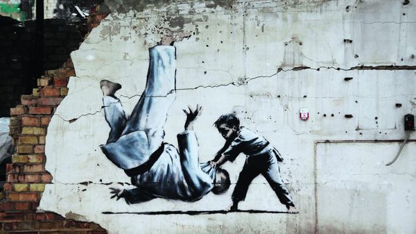 Der britische Streetart-Künstler Banksy hat in Borodjanka eine Hauswand zum Kunstwerk gemacht. Ein kleiner ukrainischer Junge wirft beim Judo Putin auf die Matte. Daraus hat die ukrainische Post zum 1. Jahrestag des russischen Überfalls eine Briefmarke gemacht. Foto: Fabian Schlüter