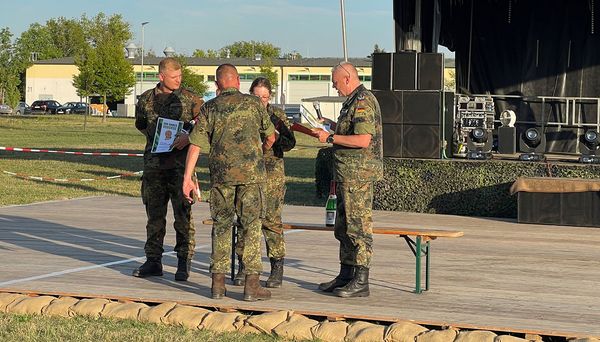 Der Kommandeur der USH, Oberst Axel Hermeling, und der Vorsitzenden der TruKa Hauptmann Becher beglückwünschen die Vertreter des erst- und zweitplatzierten Hörsaales. Foto: DBwV/Becher