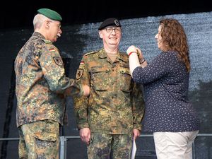Ansgar Meyer (M.) wurde am Tag der Bundeswehr in Augustdorf von Inspekteur Heer Jörg Vollmer zum Brigadegeneral befördert. Die Schulterklappen stecken Meyers Ehefrau und der Inspekteur an. Foto: DBwV/Vieth