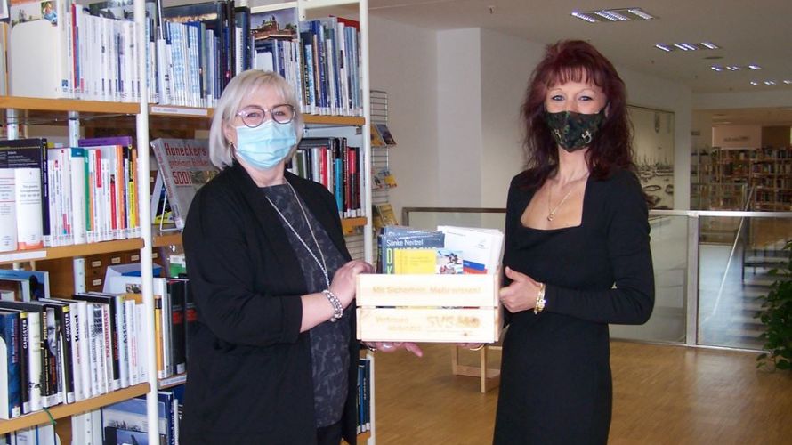 Katrin van Treek (r.) übergab der Magdeburger Bibliotheks-Mtarbeiterin Ines Gonschorek eine prall gefüllte Bücherkiste mit aktuellen sicherheitspolitischen Werken. Foto: Stadtbibliothek Magdeburg