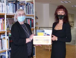 Katrin van Treek (r.) übergab der Magdeburger Bibliotheks-Mtarbeiterin Ines Gonschorek eine prall gefüllte Bücherkiste mit aktuellen sicherheitspolitischen Werken. Foto: Stadtbibliothek Magdeburg