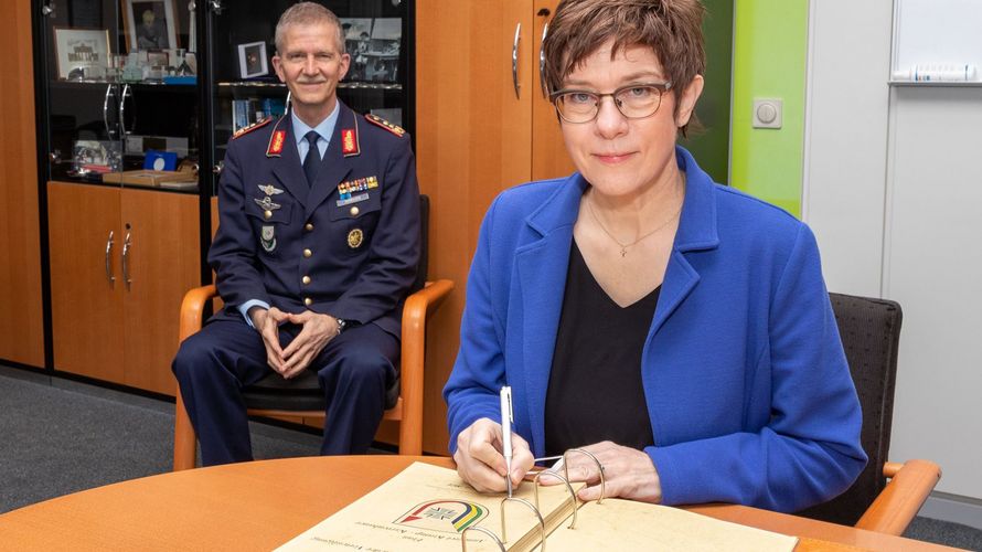 Verteidigungsministerin Annegret Kramp-Karrenbauer trägt sich unter den Augen von Generalleutnant Martin Schelleis in das Gästebuch des Kommando SKB (Streitkräftebasis) ein. Foto: Twitter/Streitkräftebasis