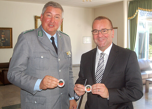 v.l.: Thomas Behr übergibt Minister Boris Pistorius eine anlässlich des Festaktes geprägte Münze („Coin“) Foto: DBwV