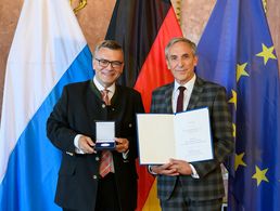 Der Leiter der Bayerischen Staatskanzlei, Dr. Florian Herrmann, überreichte Stabsfeldwebel a.D. Gerhard Stärk die Medaille für Verdienste um die Zivil-Militärische Zusammenarbeit. Foto: Joerg Koch/ Bayerische Staatskanzlei