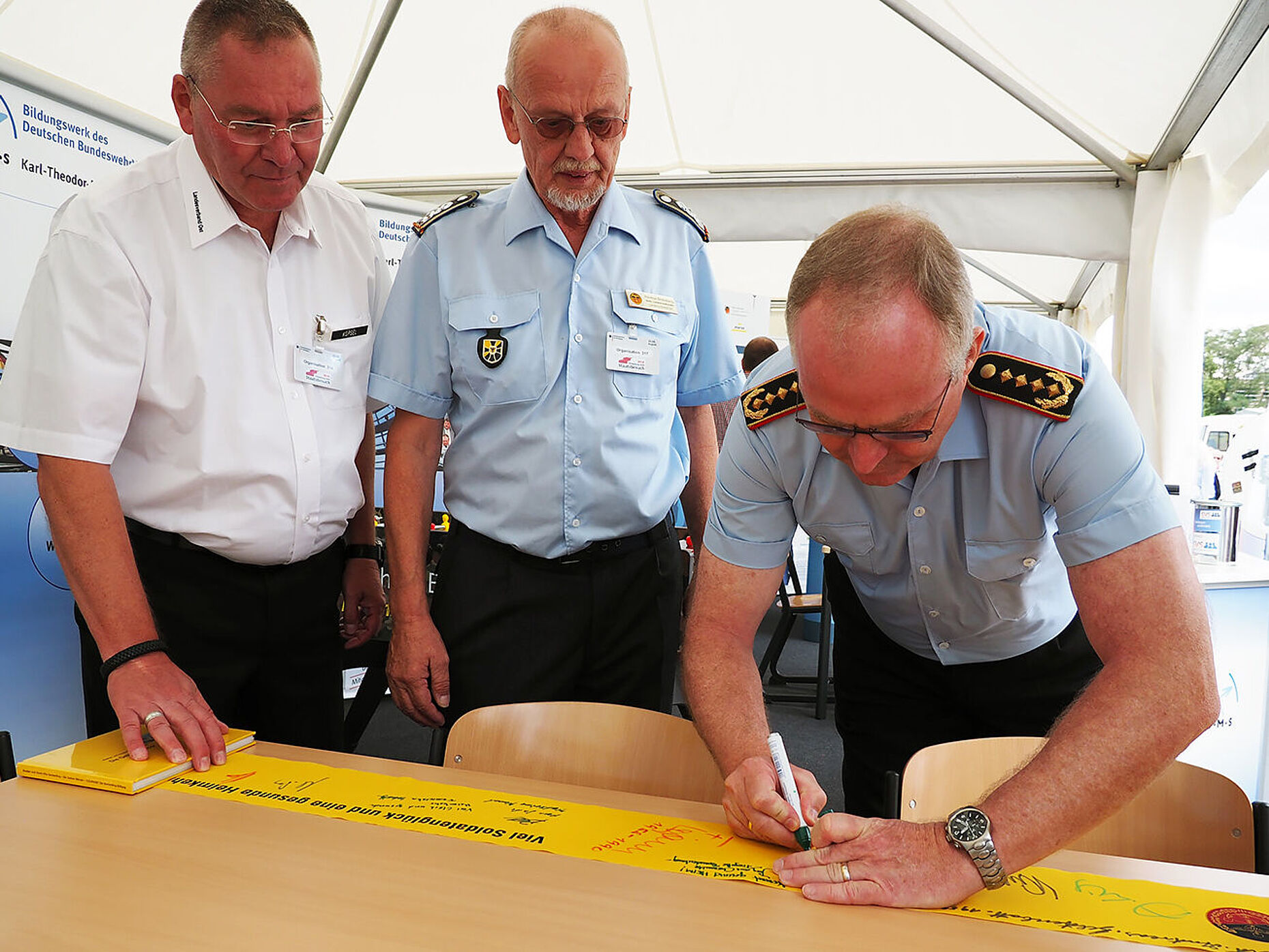 Im Beisein des Landesvorsitzenden Ost, Hauptmann a.D. Uwe Köpsel, und seines Stellvertreters, Oberstabsfeldwebel a.D. Thomas Bielenberg, unterzeichnet der Generalinspekteur, General Eberhard Zorn, ein gelbes Band der Solidarität. Foto: DBwV/Kruse 