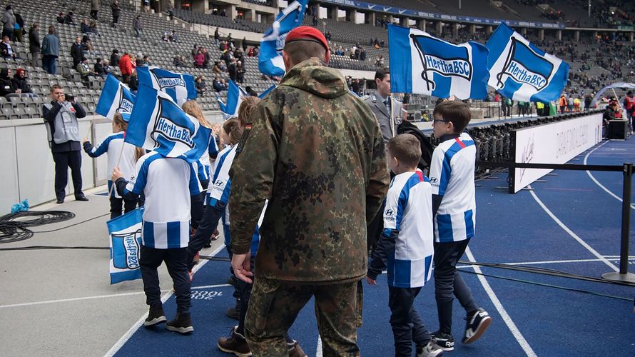 Kein alltäglicher Anblick beim Fußball: Ein Soldat mit Einlaufkindern im Berliner Olympiastadion. Foto: DBwV/Yann Bombeke