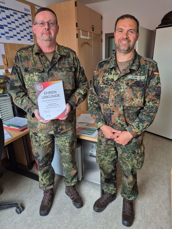 Kassenwart Stabsfeldwebel Martin Glosauer-Arnold bei seiner Ehrung an seinem Arbeitsplatz durch den StoKa-Vorsitzenden. Foto: DBwV/Roland Stengl