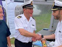 Mit einer Flasche Rum, der speziell zum 175-jährigen Jubiläum der Deutschen Marine hergestellt wurde, bedankte sich Kapitänleutnant Carsten Bracker (M.) beim Stützpunktkommandanten, Fregattenkapitän Robert Lehmann (r). Foto: Olaf Pietrzak