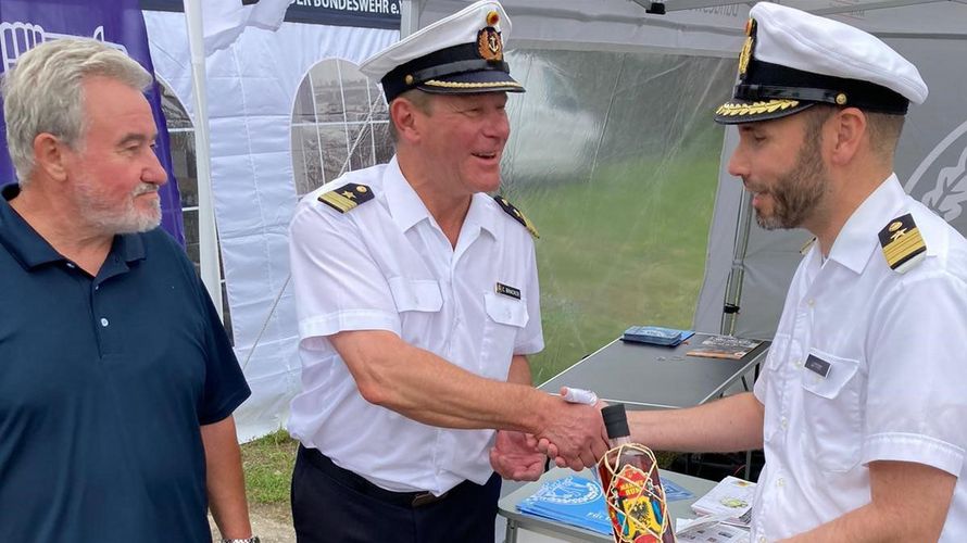 Mit einer Flasche Rum, der speziell zum 175-jährigen Jubiläum der Deutschen Marine hergestellt wurde, bedankte sich Kapitänleutnant Carsten Bracker (M.) beim Stützpunktkommandanten, Fregattenkapitän Robert Lehmann (r). Foto: Olaf Pietrzak