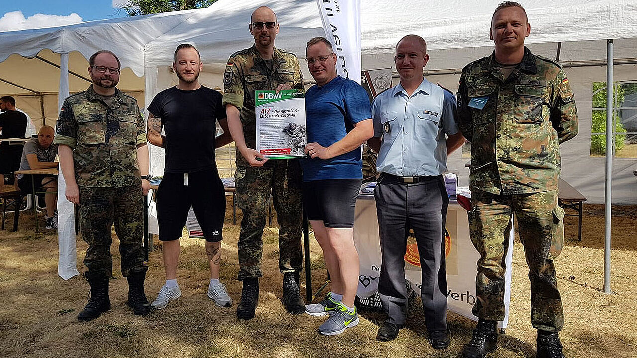 Hptm Weber (2.v.l.) mit Mitgliedern und der Forderung des Verbandes zum ATZ. Foto: DBwV/Winter