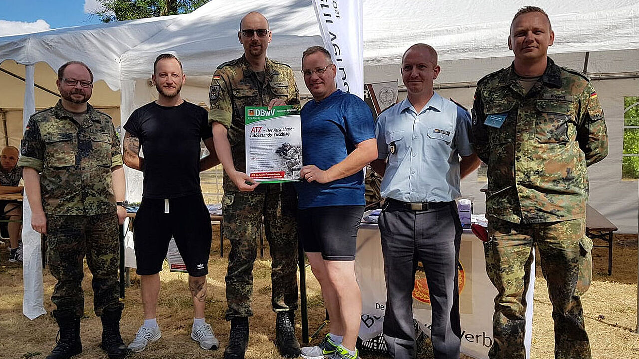 Hptm Weber (2.v.l.) mit Mitgliedern und der Forderung des Verbandes zum ATZ. Foto: DBwV/Winter