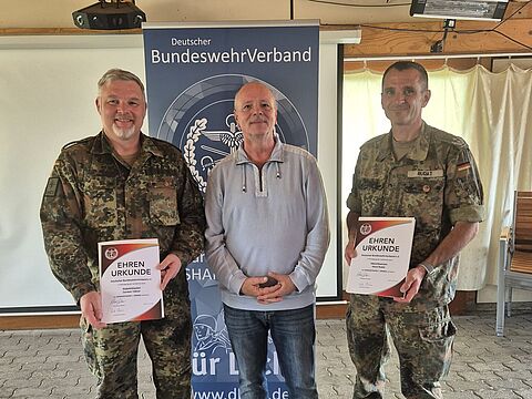 Passend zum Wechsel des TruKa Vorsitzes von Oberstleutnant Rudat (re) an Stabsfeldwebel Tüllner (li) dankte der Bezirksvorsitzender Hauptmann a.D. Michael Grothe zunächst noch den beiden Mandatsträgern für ihr Engagement und überreichte beiden die DBwV Ehrennadel in Bronze. Foto: Truka SHAPE