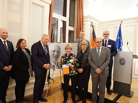 Philip Kraft und Tanja Menz (von links), beide Stellvertretende Vorsitzende der Deutschen Härtefallstiftung, Wehrbeauftragter a.D. Reinhold Robbe (SPD), Bärbel Gertz, Herausgebrin Birgitt Heidinger, und Christian Schmidt (CSU), Bundesminister a. D. und Hoher Repräsentant für Bosnien und Herzegowina. Hinten Oberst André Wüstner und Generaloberstabsarzt a. D. Dr. Ulrich Baumgärtner, der Vorstandsvorsitzende der Deutschen Härtefallstiftung. Foto: DBwV/Eva Krämer