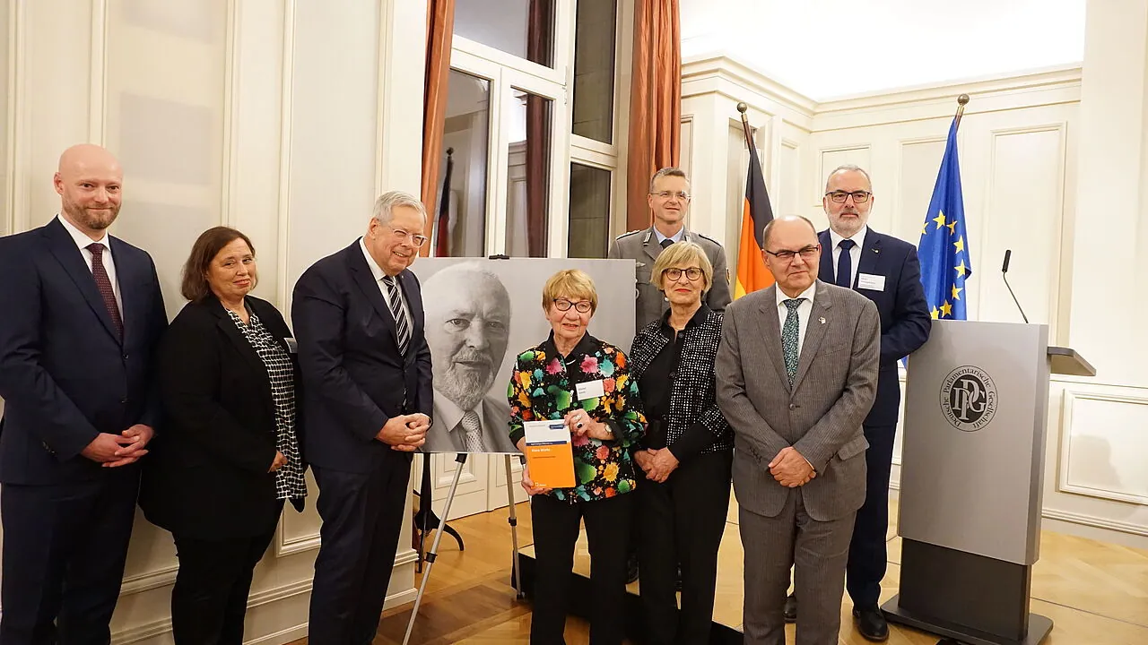 Philip Kraft und Tanja Menz (von links), beide Stellvertretende Vorsitzende der Deutschen Härtefallstiftung, Wehrbeauftragter a.D. Reinhold Robbe (SPD), Bärbel Gertz, Herausgebrin Birgitt Heidinger, und Christian Schmidt (CSU), Bundesminister a. D. und Hoher Repräsentant für Bosnien und Herzegowina. Hinten Oberst André Wüstner und Generaloberstabsarzt a. D. Dr. Ulrich Baumgärtner, der Vorstandsvorsitzende der Deutschen Härtefallstiftung. Foto: DBwV/Eva Krämer