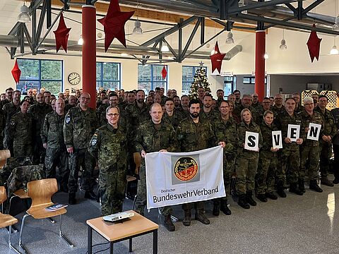 Oberst André Wüstner, Vorsitzender Deutscher BundeswehrVerband, besuchte die Personalversammlung im ZOpKomBw. Die Soldatinnen und Soldatenhalten den Namen „Sven" für einen erkrankten Kameraden hoch. Foto: Nathalie Neuhaus