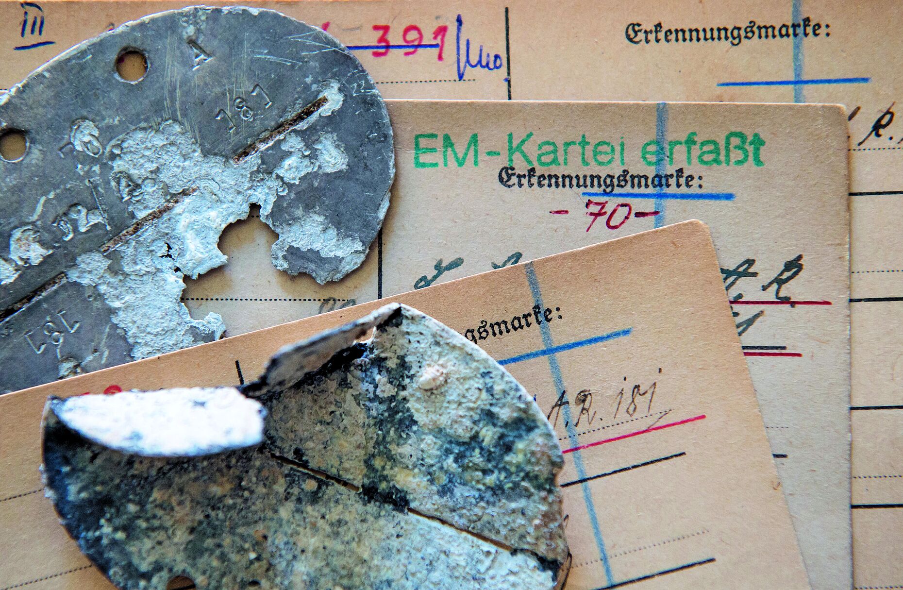 Erkennungsmarken deutscher Soldaten und Karteikarten der deutschen Dienststelle für die Benachrichtigung der näcsten Angehörogen von Gefallenen der ehemaligen deutschen Wehrmacht (WASt) liegen in der Dienstelle in Berlin übereinander. Foto: Tim Brakemeier/dpa