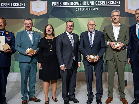 Verteidigungsminister Boris Pistorius (M.), Bundestavizepräsidentin Yvonne Magwas und Gerd Landsberg, Ehrengeschäftsführer des Deutschen Städte- und Gemeindebundes (r.), mit den Preisträgern Stabsfeldwebel Michael Eichstaedt (l.), Marienbergs Oberbürgermeister André Heinrich (2.v.l.), Klaus Kunzmann, Geschäfstführender Gesellschafter der Patenschaftsgesellschaft Marineschiffe Karlsruhe (3.v.r.) und Oliver Sluka, Leiter der Berufsschule 7 in Augsburg. Foto: Bundeswehr/Tom Twardy