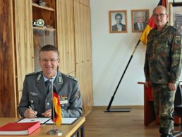 Oberstleutnant André Wüstner trägt sich in das Gästebuch der Artillerieschule ein, rechts daneben Oberst Dietmar Felber. Foto: ArtS