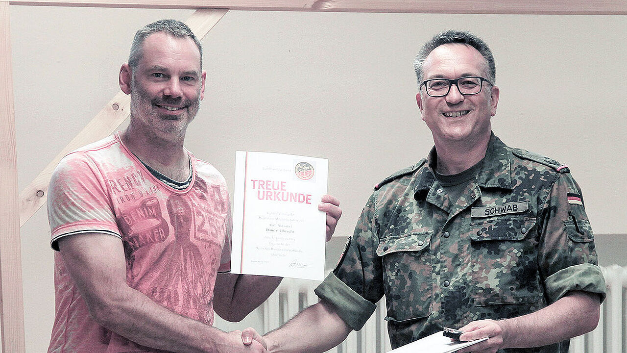 Die Corona-Lage lässt es wieder zu: Bezirksvorsitzender Oberstleutnant Michael Schwab (r.)  freut sich, Mitgliederehrungen wieder in angemessenem Rahmen vornehmen zu können. Foto: DBwV         