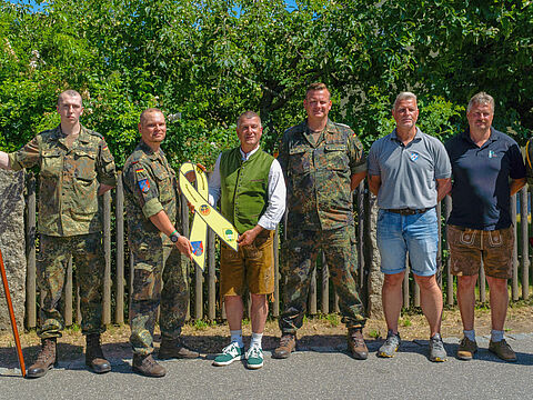 Batteriechef Major Lars P. von der 4./PzArtBtl 375 überreichte gemeinsam mit Bezirksvorsitzendem Stabsfeldwebel Christian Schleicher die „Gelbe Schleife“ an den Bürgermeister der Gemeinde Pirk, Dietmar Schaller. Fotos: Mario Hönig