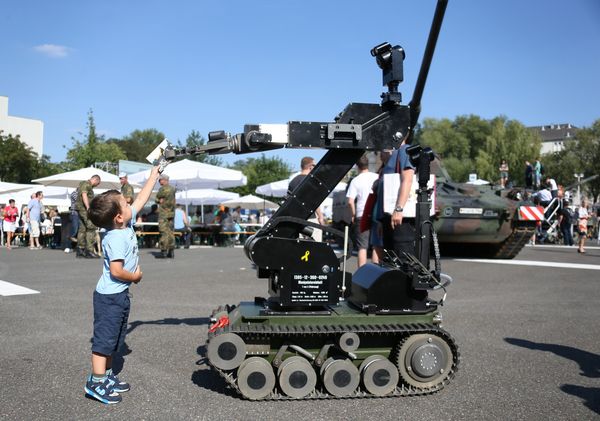 Ein kleiner Junge bekommt am Tag der offenen Tür der Bundesregierung eine Postkarte vom Dekontaminationsmodul "teODor" überreicht Foto: Bundeswehr