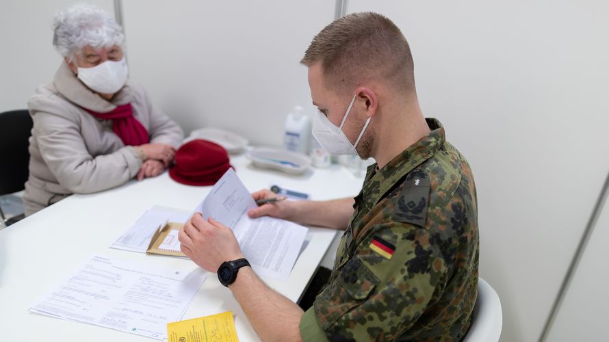 Ein Fliegerarzt führt im Januar 2021 mit der zu impfenden Person ein Vorgespräch im Corona-Impfzentrum am Flughafen BER in Schönefeld. Nun kommen wieder Soldaten der Bundeswehr in Berliner Impfzentren zum Einsatz. Archivfoto: Bundeswehr/Tom Twardy