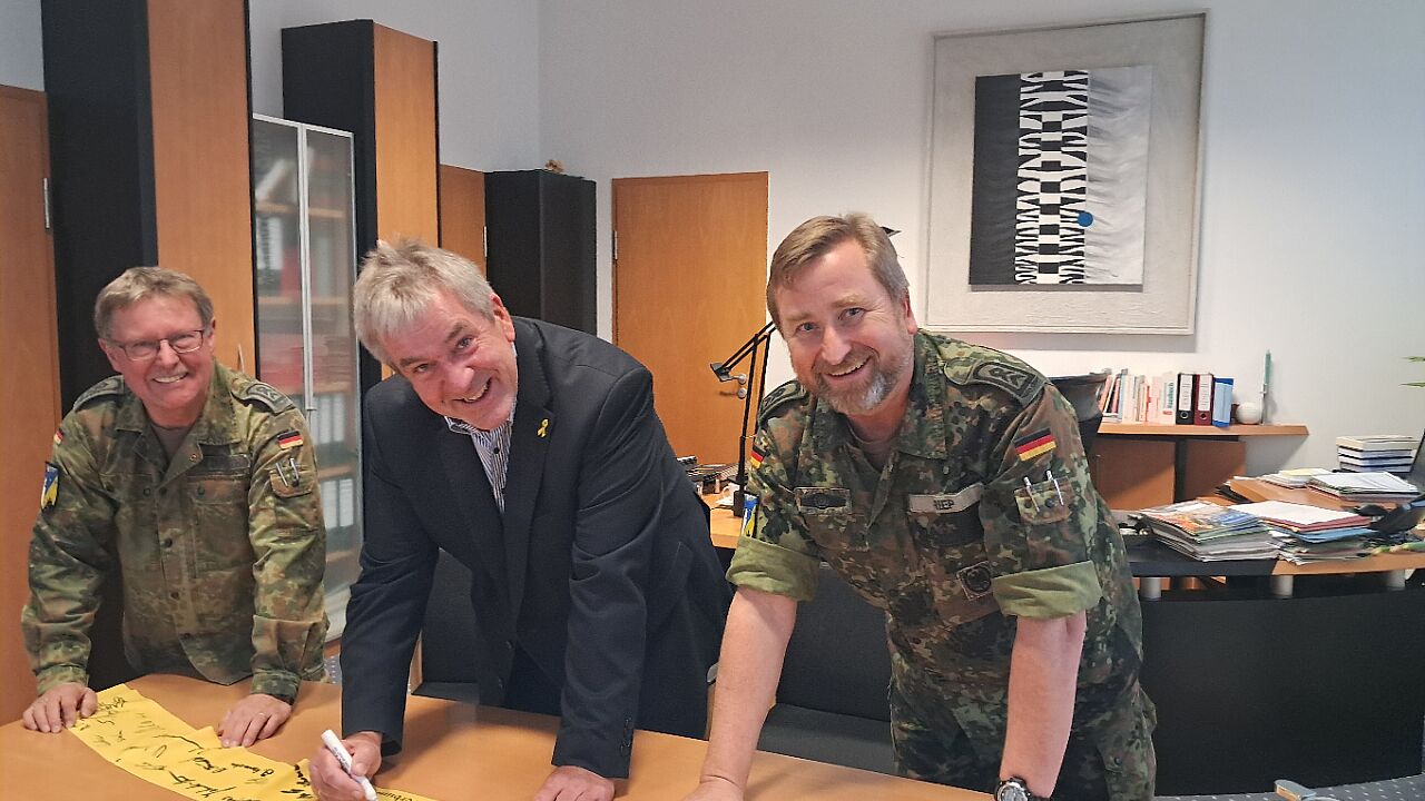 Die Gelben Bänder der Verbundenheit sind ein kleines Zeichen der Anerkennung der an die Soldatinnen und Soldaten im Einsatz. In Brakel-Auenhausen beteiligten sich (von links) sowohl der stellvertretende Landrat Werner Dürdoth wie auch Bürgermeister Hermann Temme an der Aktion, die durch den TruKa Vorsitzenden Stabsfeldwebel Stefan Riep initiiert wurde. Foto: Stadt Brakel