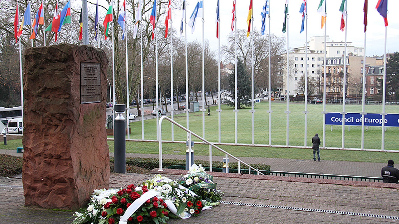 Blumen vor dem "Auschwitz-Gedenkstein" in Strasbourg. Foto: DPA