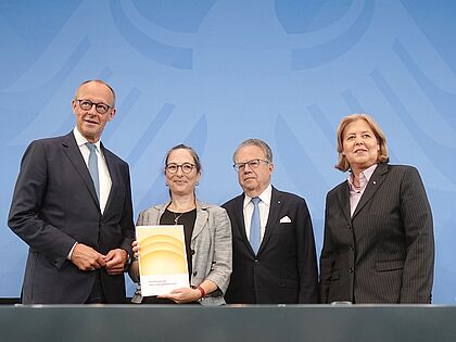 Die Vorsitzenden der Kommission Prof. Constanze Janda (2. von links) und Frank-Jürgen Weise (2. von rechts) übergeben den Bericht der Alterssicherungskommission über umfassende Schritte als Grundlage für eine Rentenreform an Bundeskanzler Friedrich Merz (CDU) und Bärbel Bas (SPD), Bundesministerin für Arbeit und Soziales. Foto: picture alliance/dpa/Kay Nietfeld
