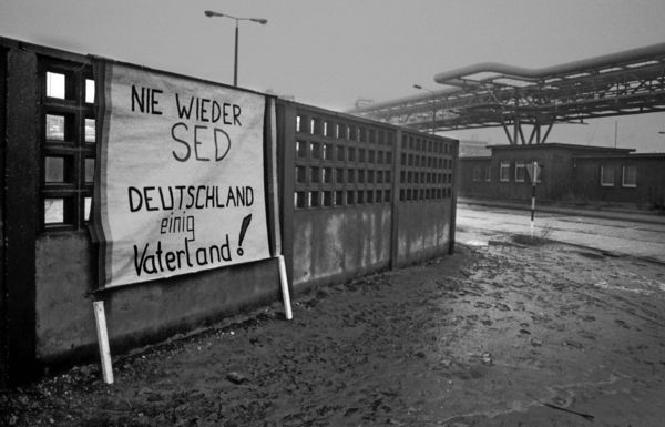 Auf dem riesigen heruntergekommenen Firmengelände des Chemiekombinats in Bitterfeld hat jemand ein Schild an die Mauer gestellt: „Nie wieder SED, Deutschland einig Vaterland!“ Foto: picture alliance/Paul Glaser