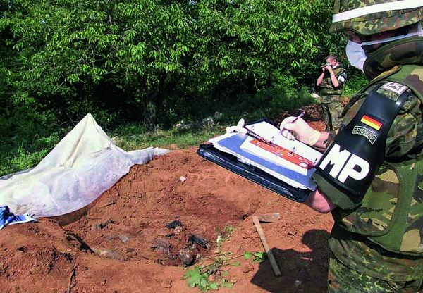 Soldaten der Militärpolizei untersuchen ein von Dorfbewohnern unweit von Prizren entdecktes Grab mit vier toten Männern. Foto: picture-alliance/dpa