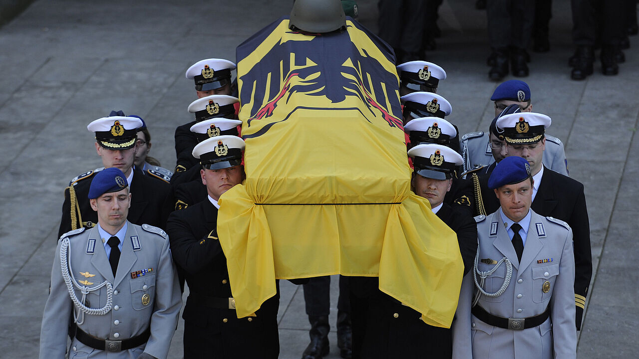 Ein Sarg wird am 24. April 2010 aus dem Münster von Ingolstadt (Oberbayern) getragen. Bundeswehr, Politiker, Familie und Freunde verabschiedeten sich bei einer Zentralen Trauerfeier von den vier am 15. April in Afghanistan getöteten Soldaten. Foto: dpa