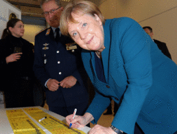 Bundeskanzlerin Angela Merkel unterzeichnet ein Gelbes Band. Foto: DBwV/Mika Schmdt